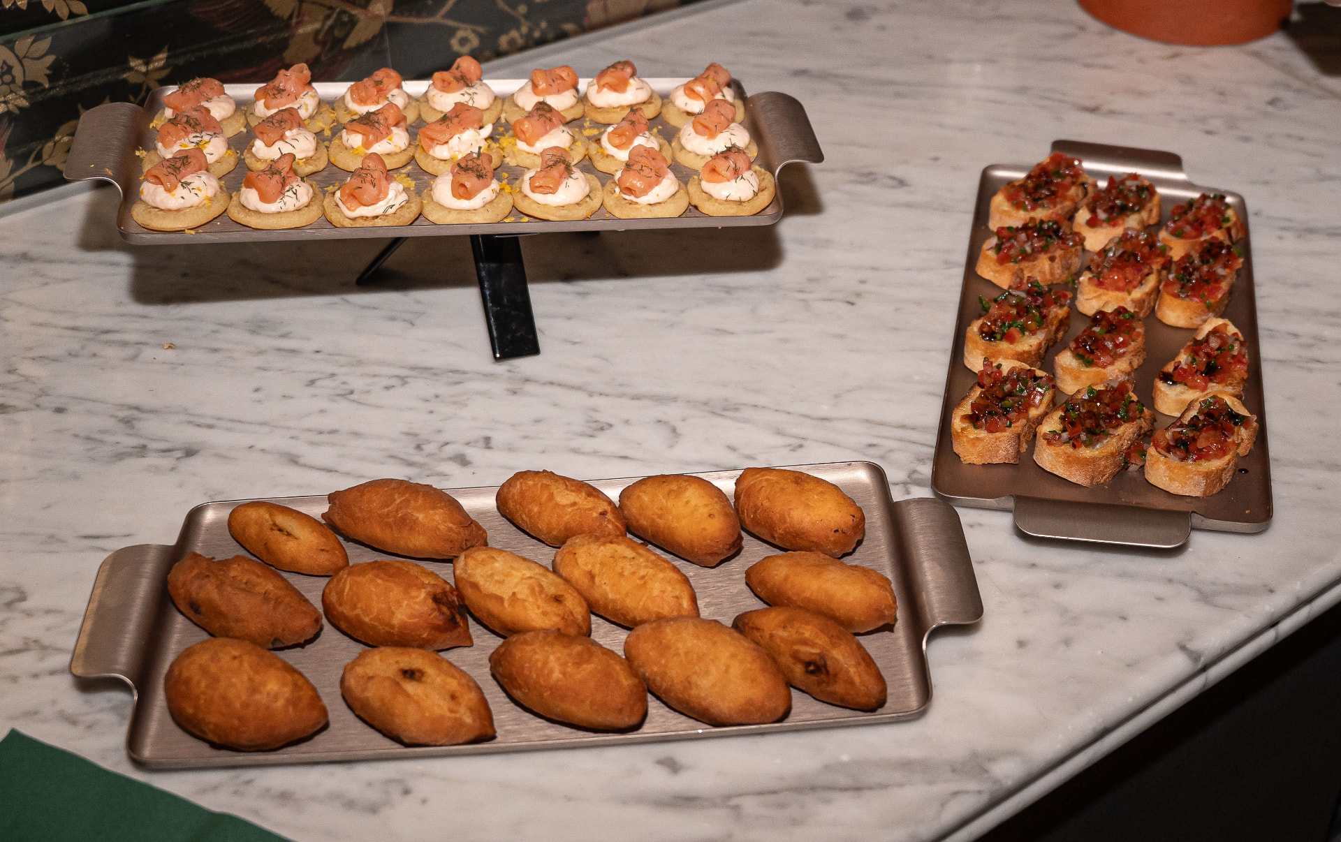 Plateaux de bouchées cocktail, bruschettas et beignets servis sur marbre