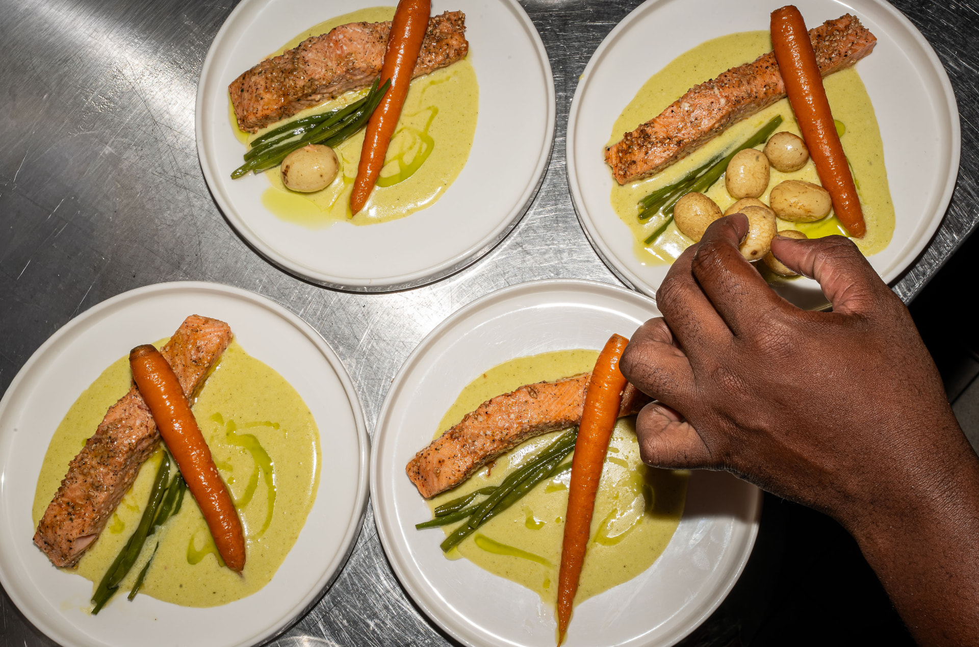 Assiettes de saumon, carottes glacées et pommes grenailles, dressées à la main